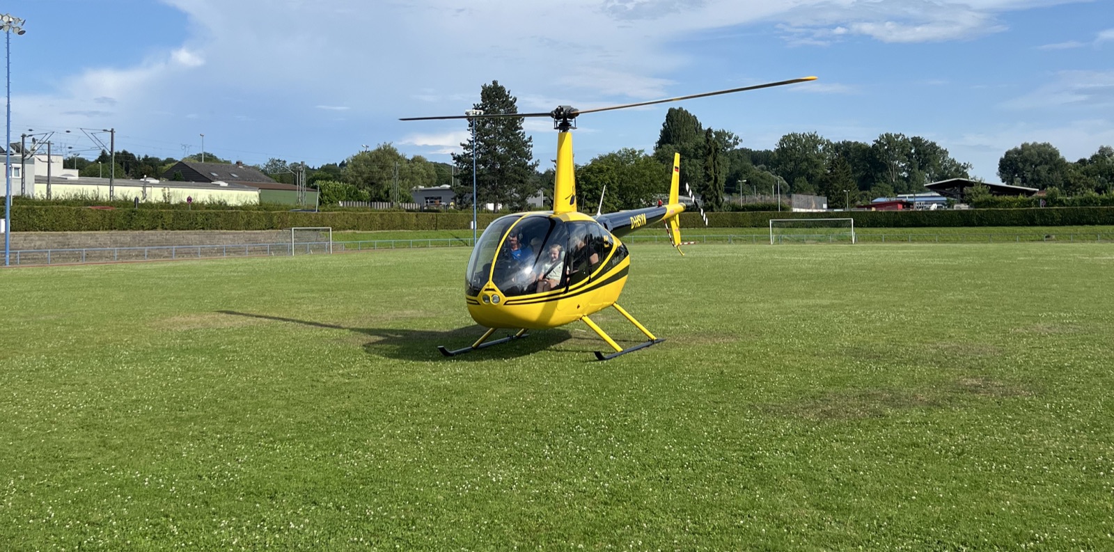 Gelbe Robinson R44 von Airkraft Helicopter auf dem Landeplatz