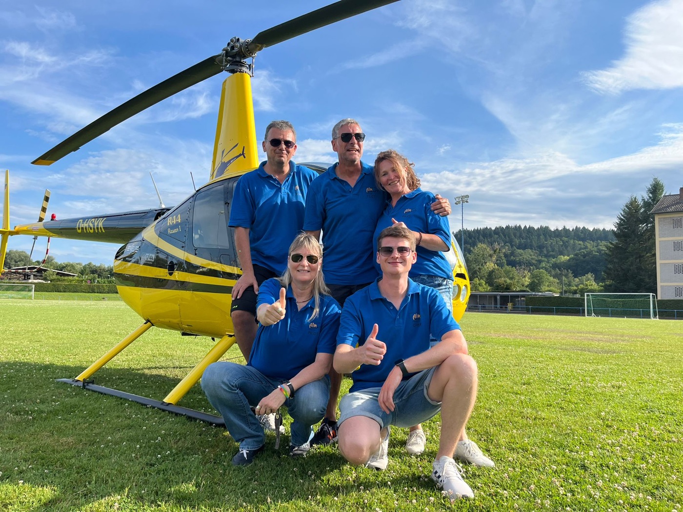 Das Team von Airkraft Helicopter vor der gelben Robinson R44